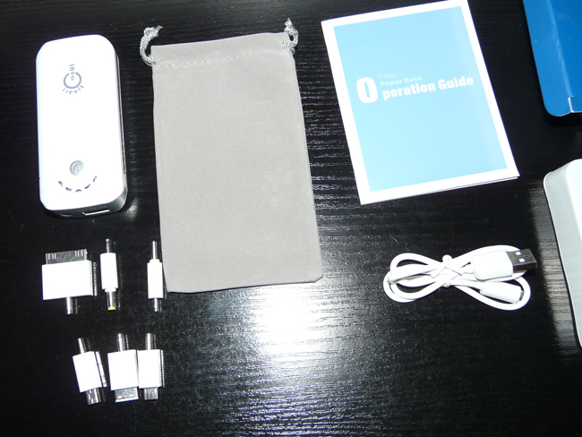 L'ensemble du coffret : la batterie, les connecteurs, la sacoche de rangement, le manuel et le câble USB avec l'embout multi-usage